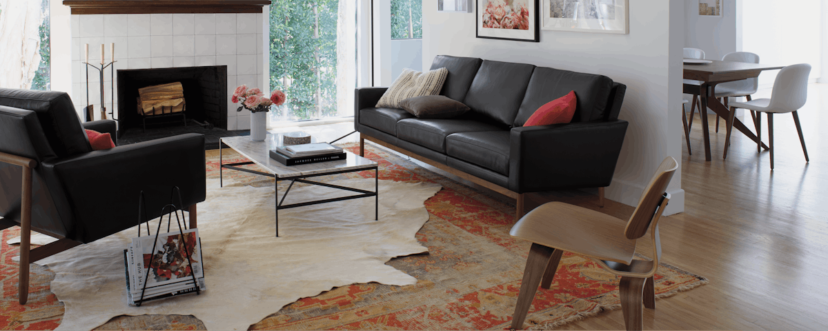 Cowhide Rug under Outline Rectangular Coffee Table in front of Raleigh Sofa in living room setting