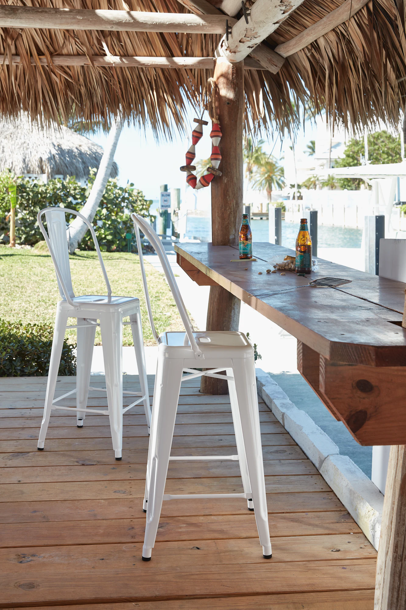White Tolix-style counter stool outdoors on wooden deck