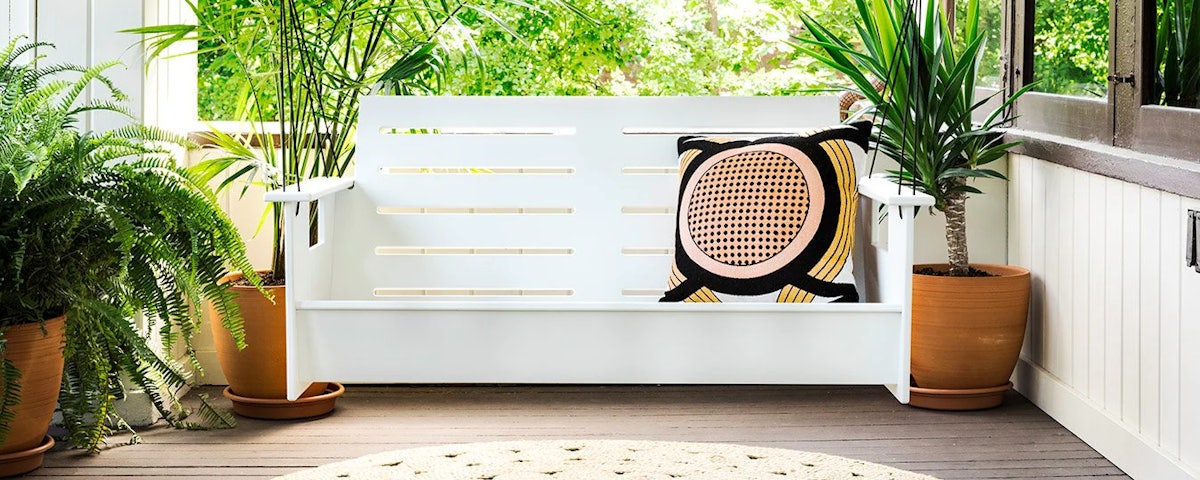 Go Porch Swing in an outdoor house porch setting with plants