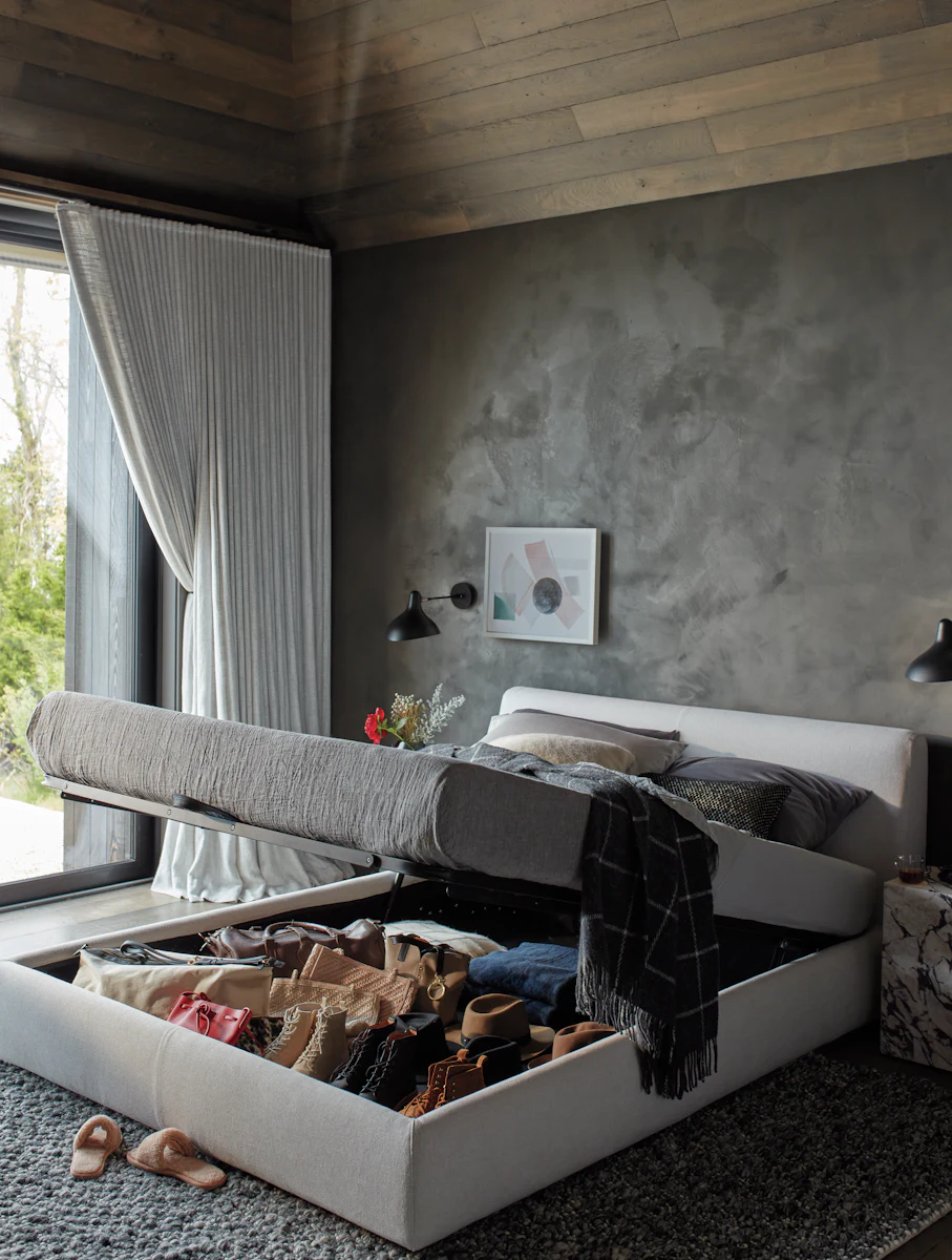 Close-up of a dark fabric upholstered bed base with lift mechanism