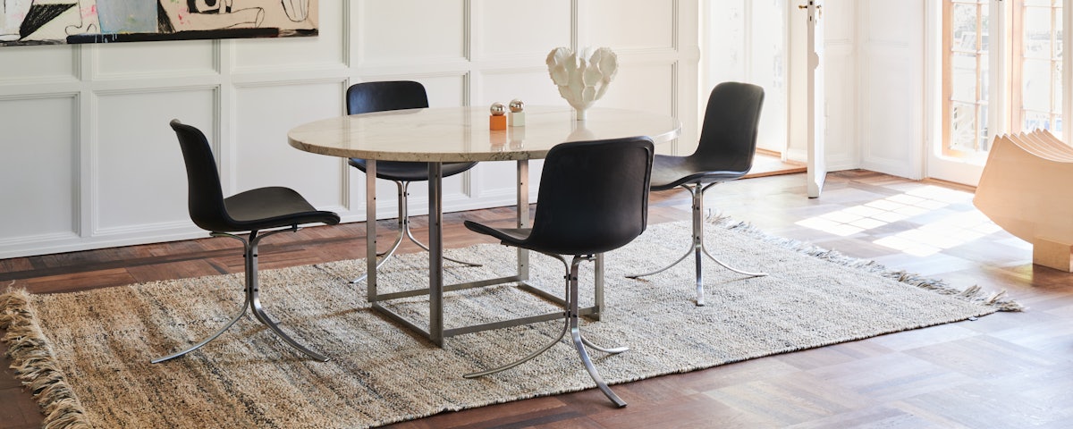 Four PK9 Dining Chairs surrounding a dining table in a dining room setting