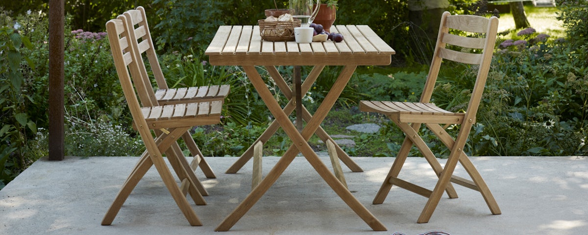 Selandia Dining Chairs surrounding a Selandia Dining Table in an outdoor patio setting