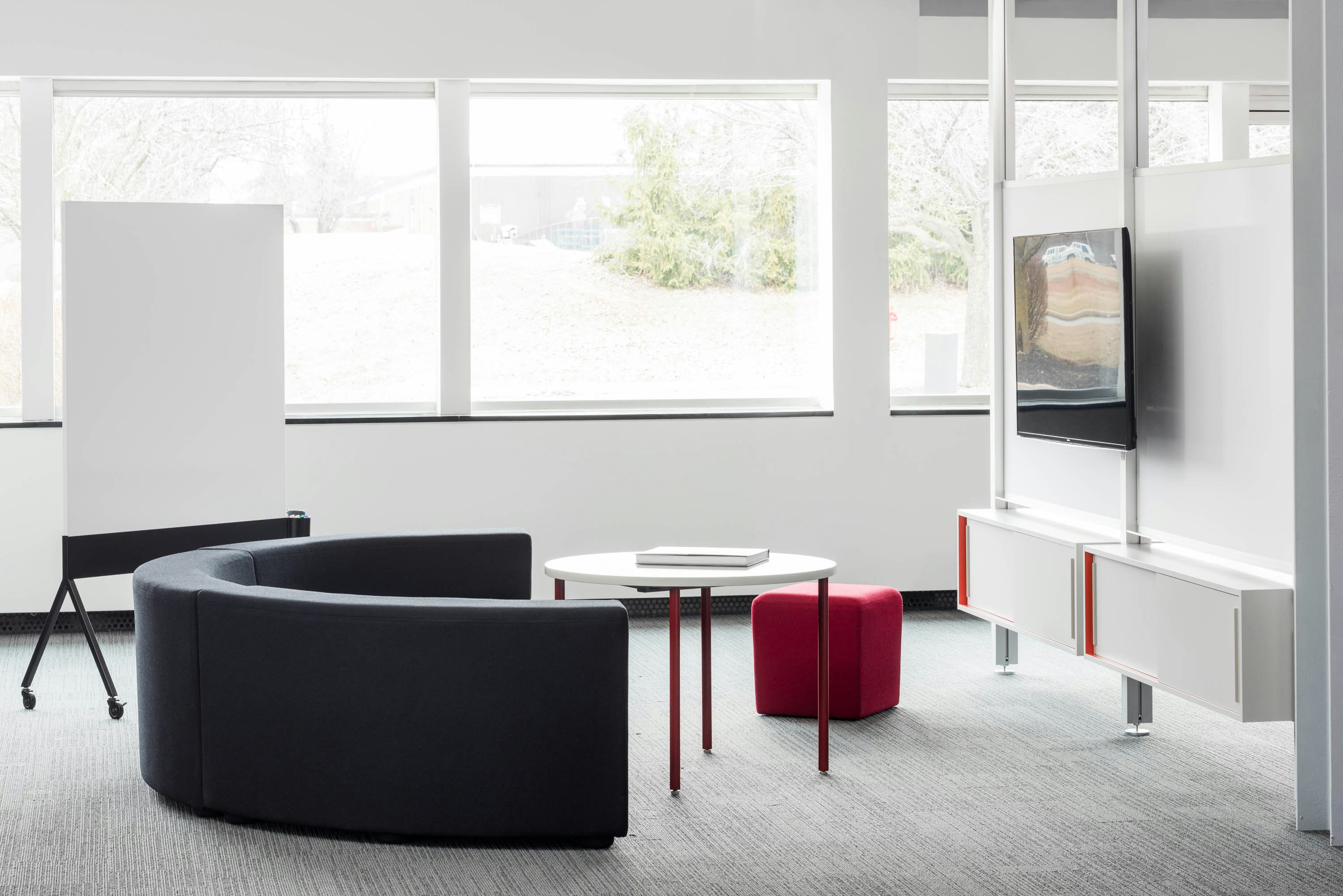 Knoll Interpole with grey k lounge and red Antenna Simple Table for Activity Spaces and other meeting spaces.