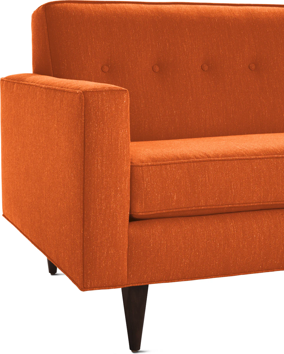 Orange upholstered sofa with square armrests and tapered wooden legs.