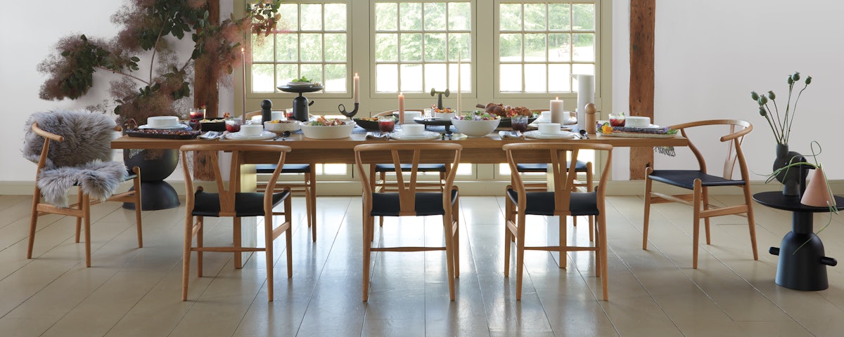 Gather Dining Table and Wishbone Dining Chairs set up for a dinner party