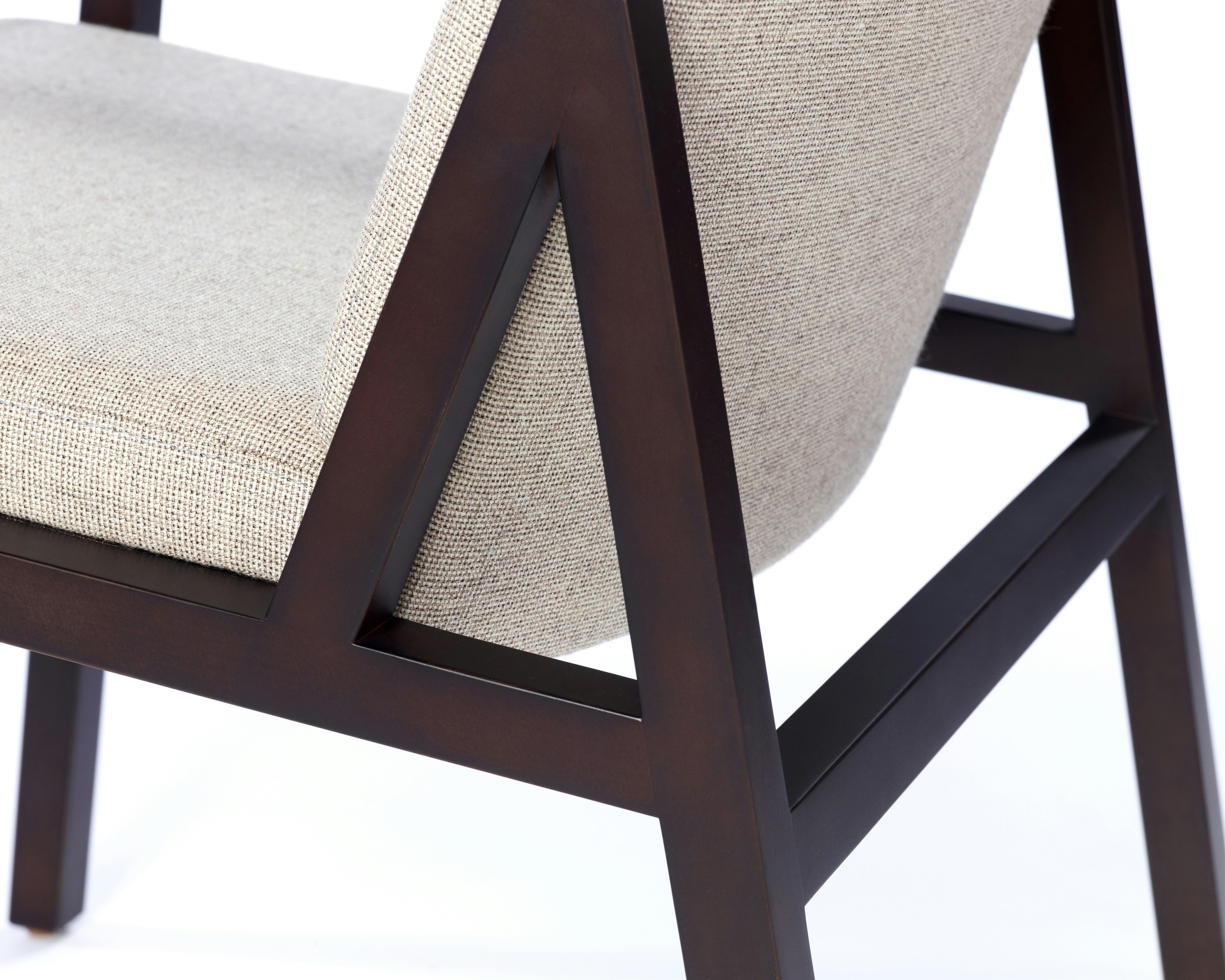 Partial view of an Ascribe Chair, showing the wood frame and upholstered seat and back.