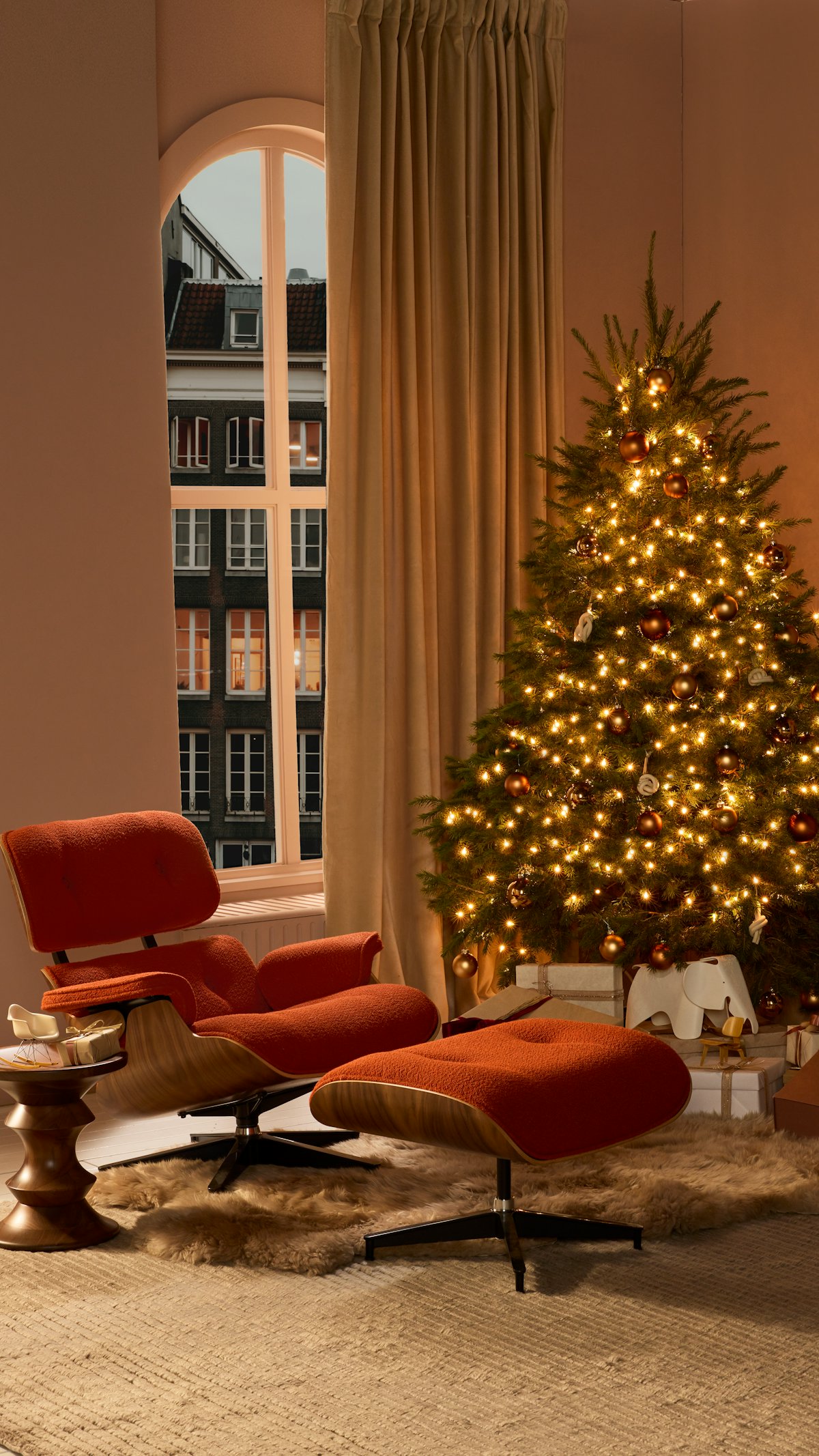 Eames Lounge Chair & Ottoman, Eames Walnut Stool and Sheepskin Throw with Christmas Tree in living room setting