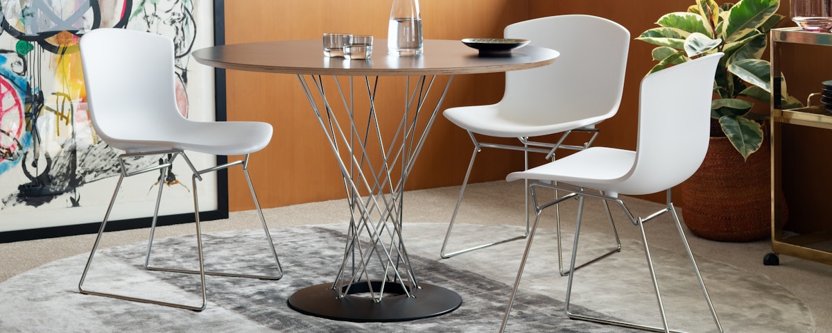 Cyclone Dining Table surrounded by three chairs in a dining room setting