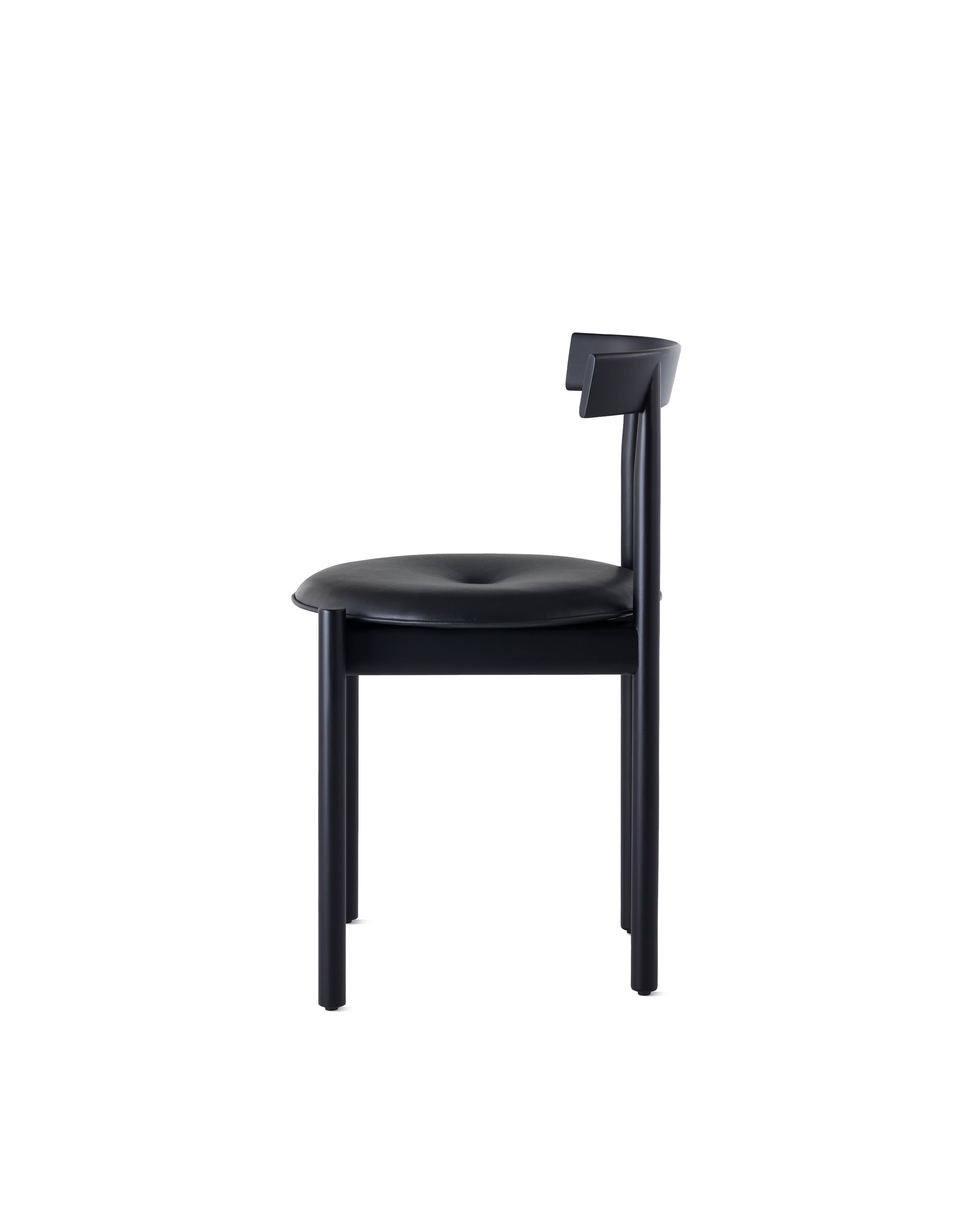 Profile view of a black Comma Chair with a seat pad.
