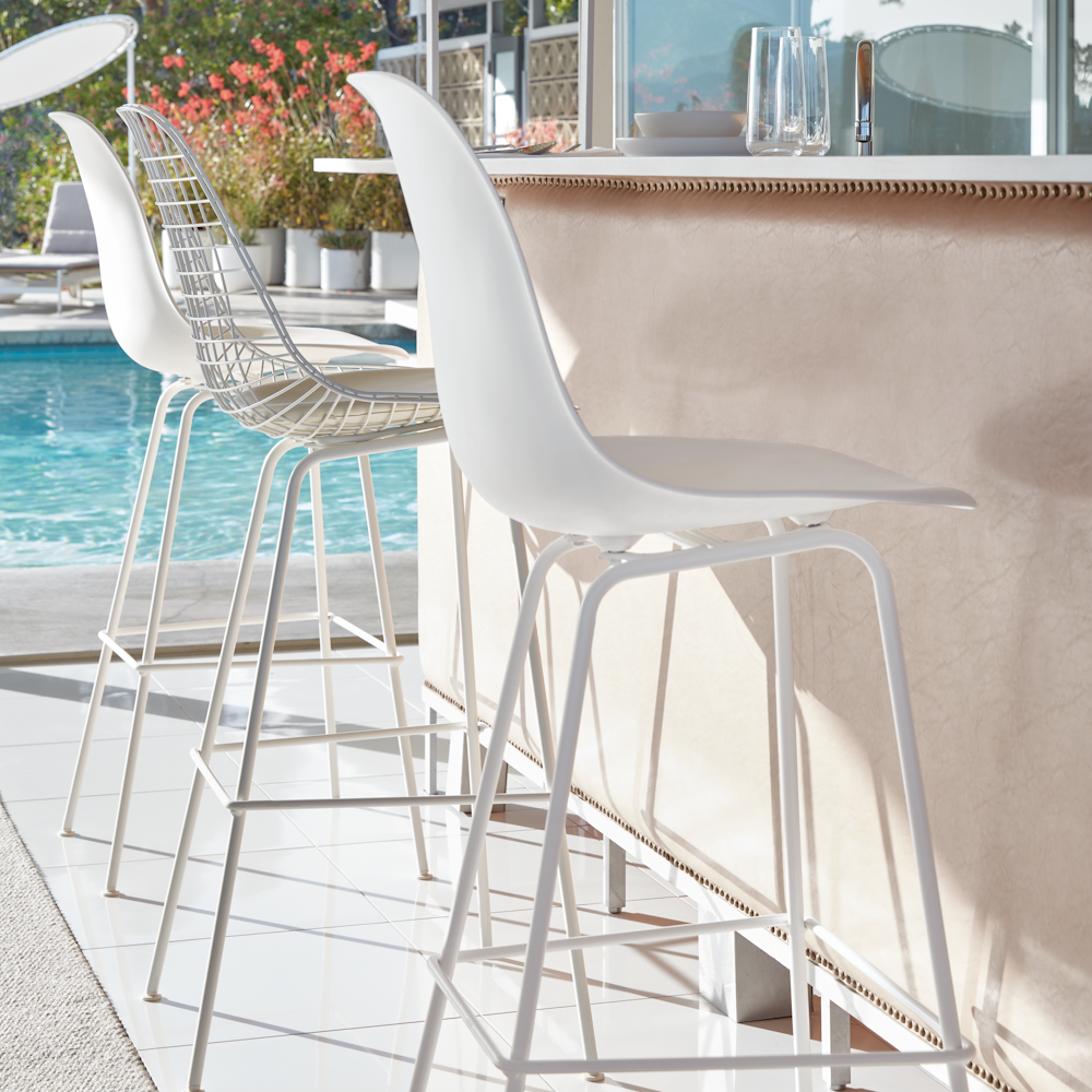 Eames Molded Plastic Barstools at a poolside cocktail bar counter
