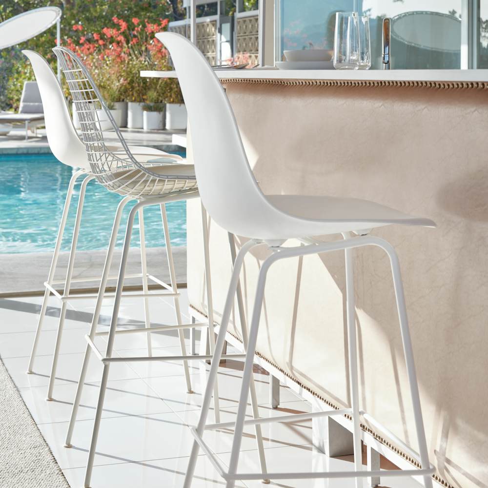 Eames Molded Plastic Barstools at a poolside cocktail bar counter