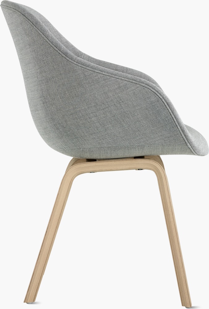 A side view of the AAC 123 About A Chair Upholstered Armchair with a wood base.
