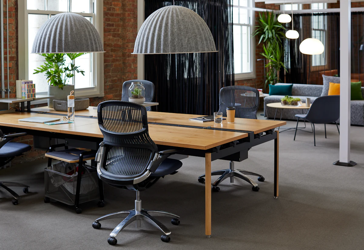 White mesh office chair in a home office setup with wooden desk and shelves