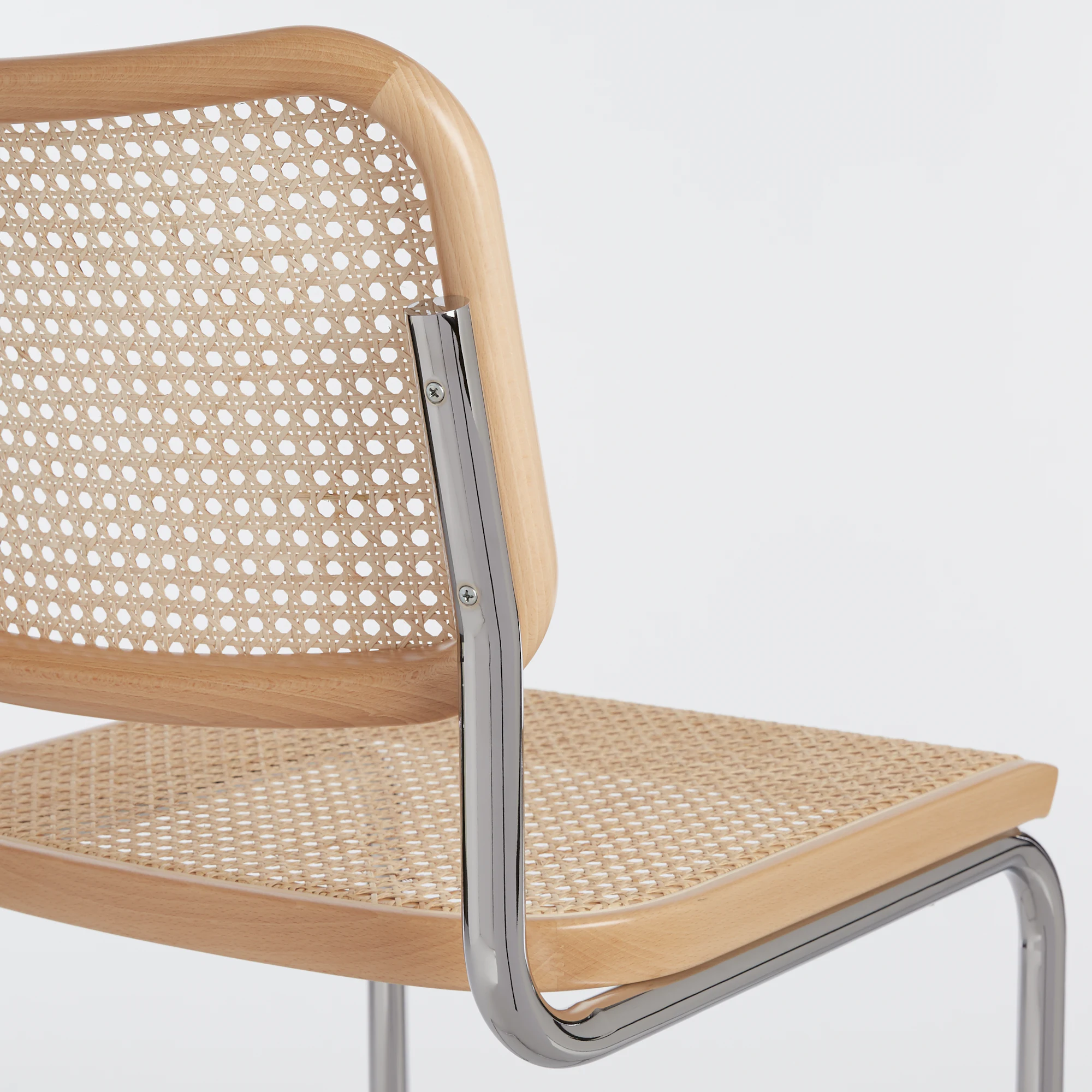Close-up of Cesca bar stool wood arm and chrome support with woven seat panel.