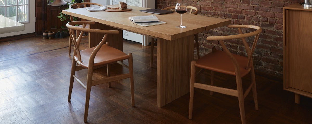 Three CH24 Wishbone Leather Seat Chairs surrounding a Gather Table in a dining room setting