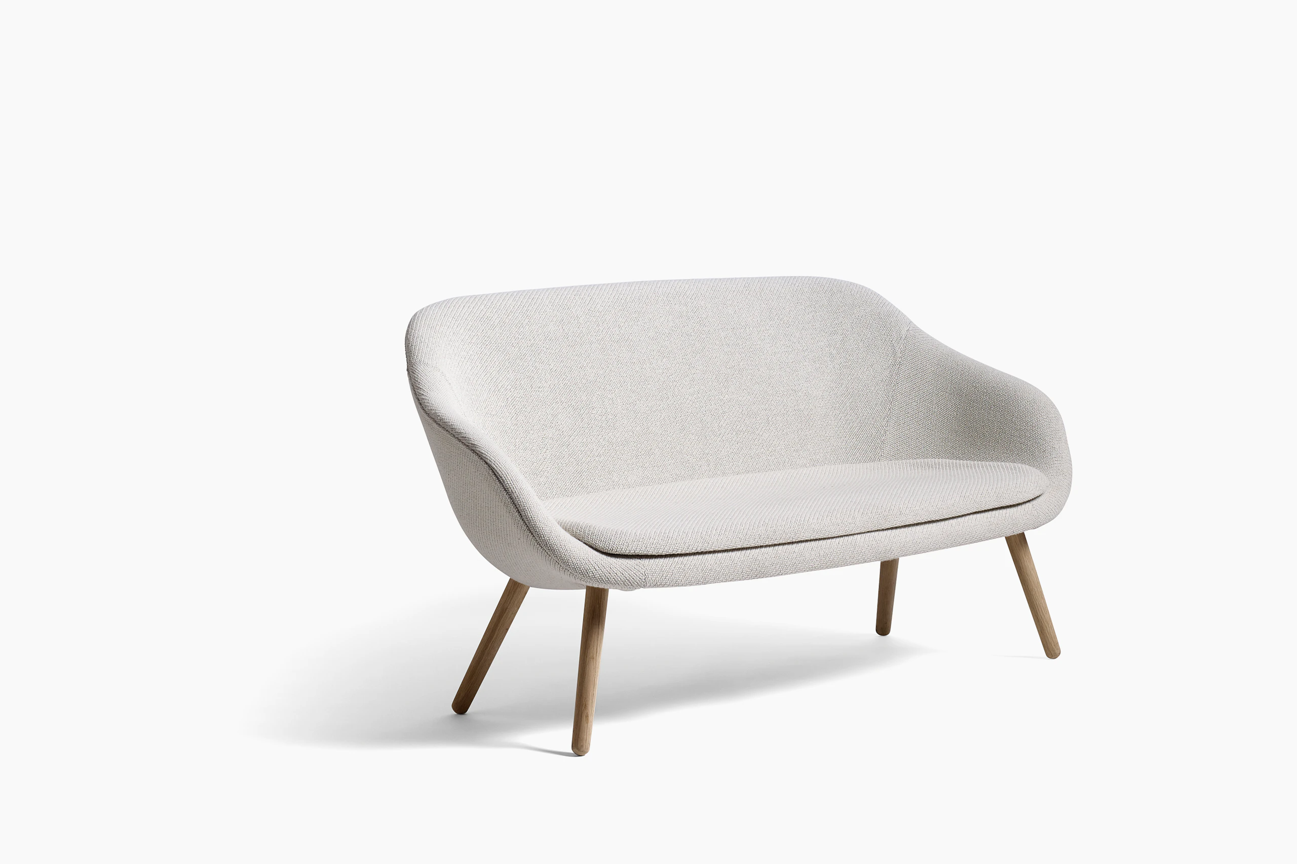 A gray About a Lounge Sofa with wooden legs, viewed from the side.