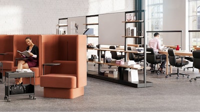 An individual reading in a burnt-orange NaughtOne Pullman chair next to Herman Miller OE1 Storage Trolleys in an individual study hall setting designed to cultivate an area of focus and wellbeing
