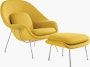 A yellow Womb Chair & Ottoman viewed from an angle