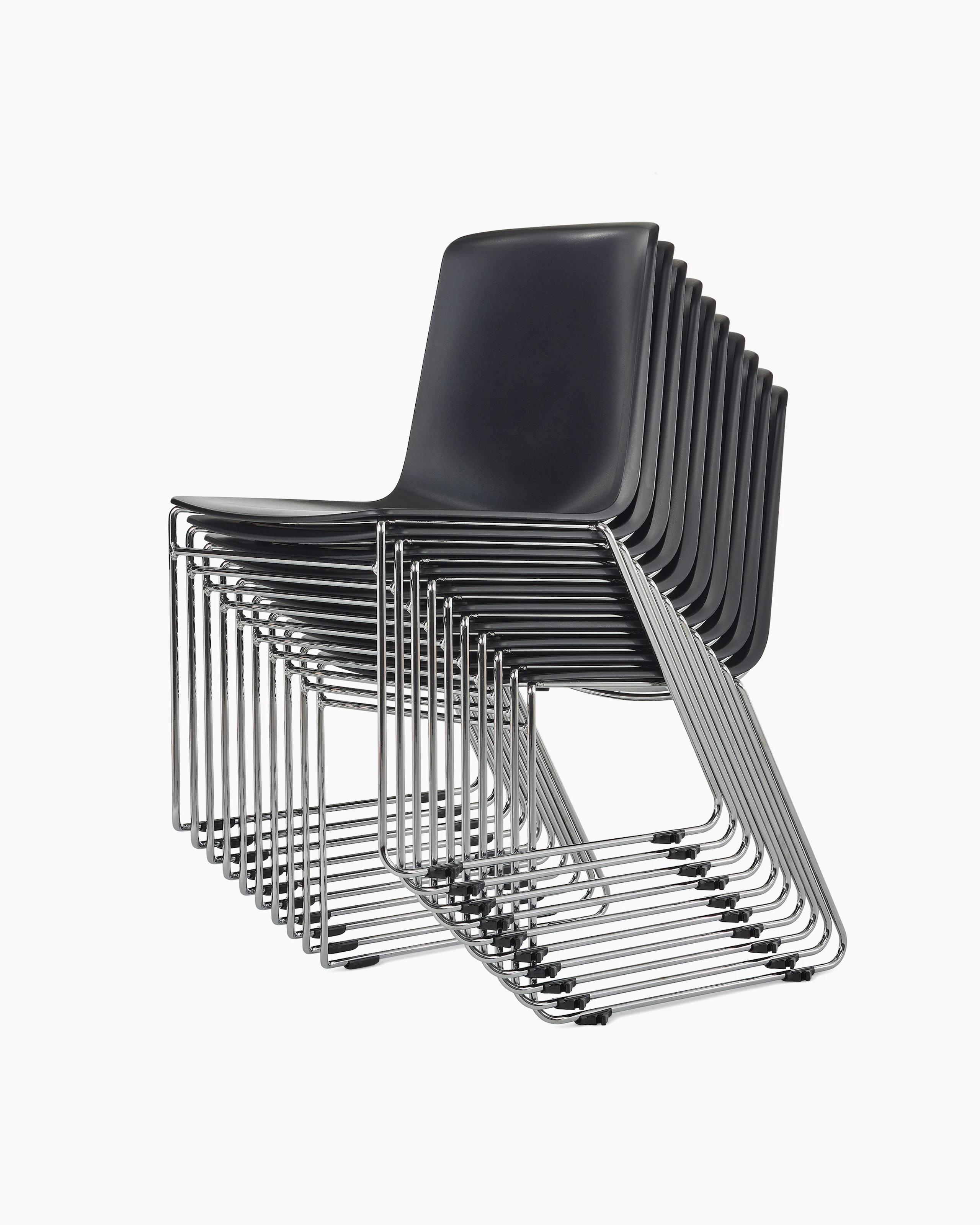 A stack of black Pronta chairs with chrome legs.